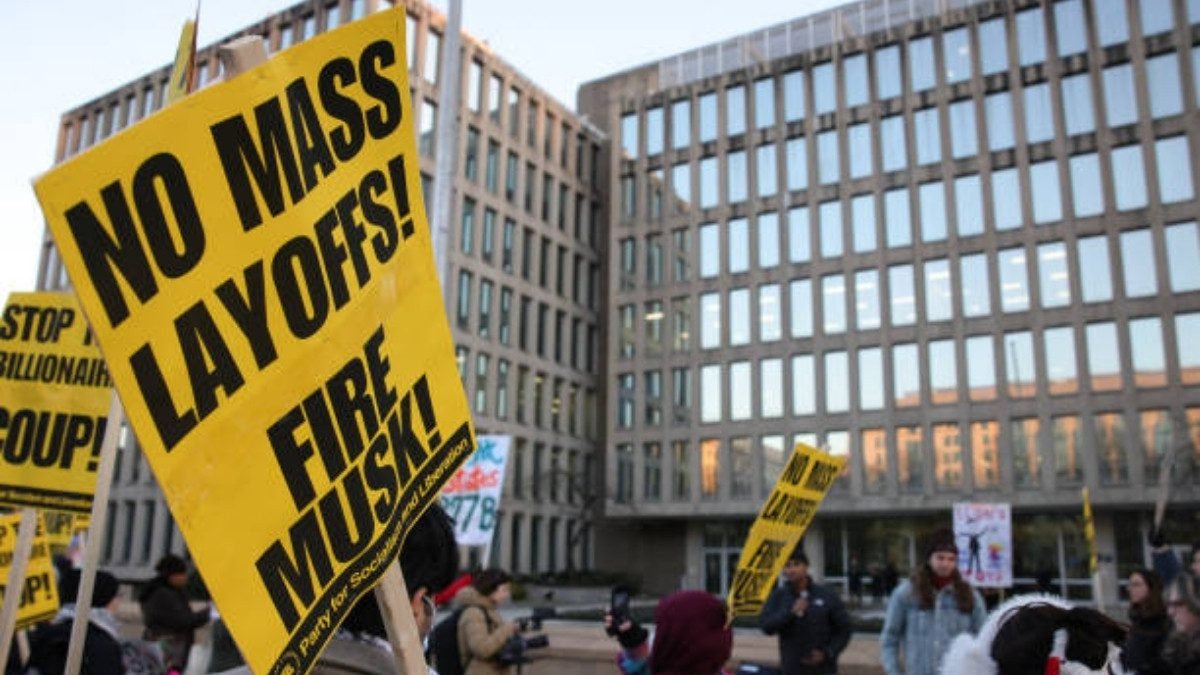 Protesters gather outside Washington, D.C.’s Office of Personnel Management on February 7, 2025, to oppose federal layoffs and call for Elon Musk’s removal from DOGE. (Photo by Bryan Dozier / Middle East Images / AFP via Getty Images)
